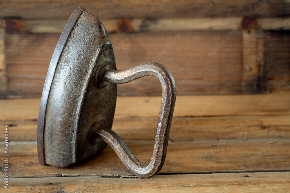 Old iron on wooden background.