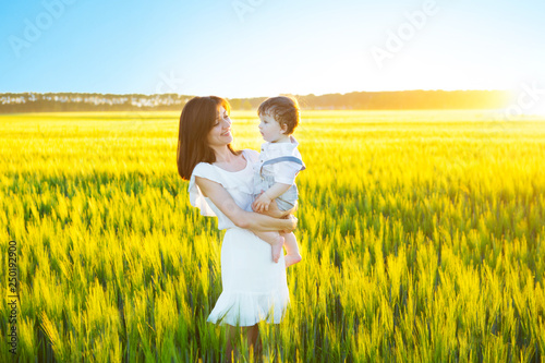 Happy family having fun. Baby boy and his mother having fun by field outdoors enjoying nature.