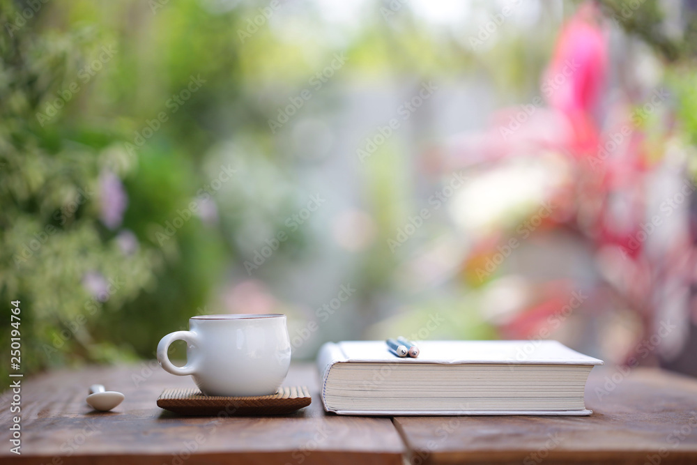 White cup with diary notebook at outdoor White cup with diary notebook at outdoor