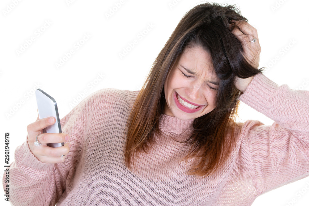 Shocked young woman looking at mobile phone on isolated white background Shocked young woman looking at mobile phone on isolated white background