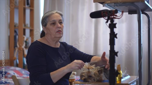 Animal Specialist blogger vlog , woman shows animal care equipment on cam. Tripod with videomic