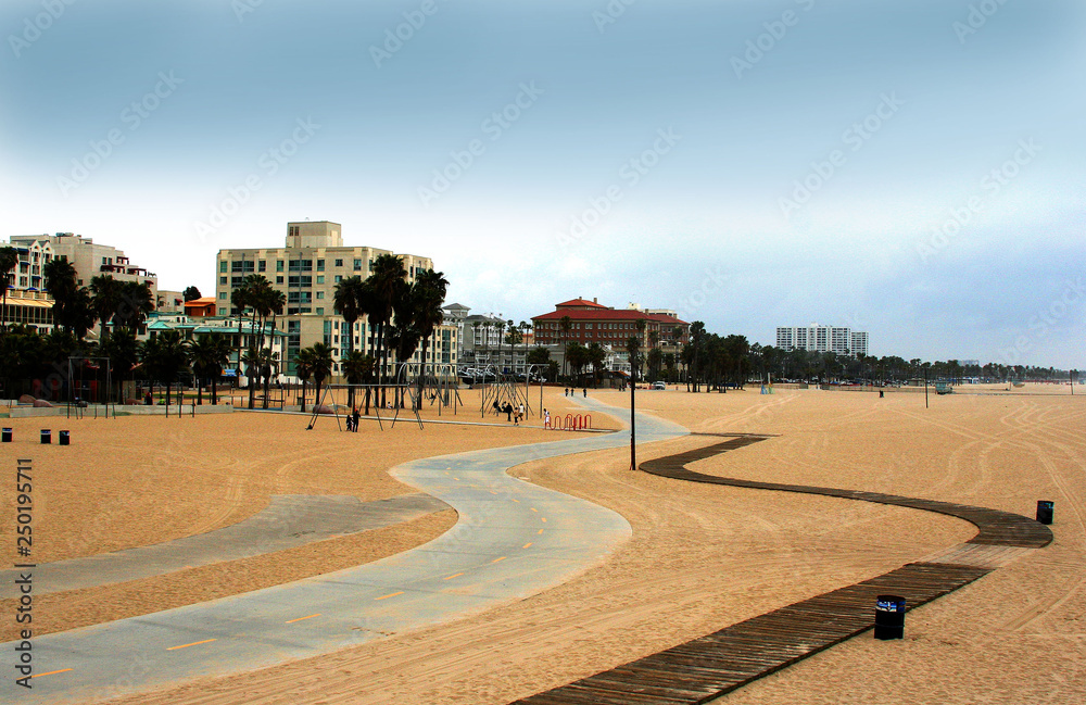 Winding beach path to luxury buildings rooted like jewels on a coastal landscape.