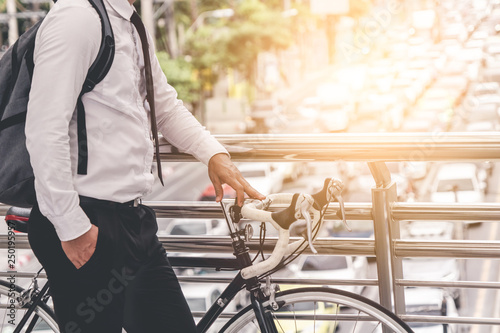 Obraz na plátně adult man on bike in the city in the morning with sun flare