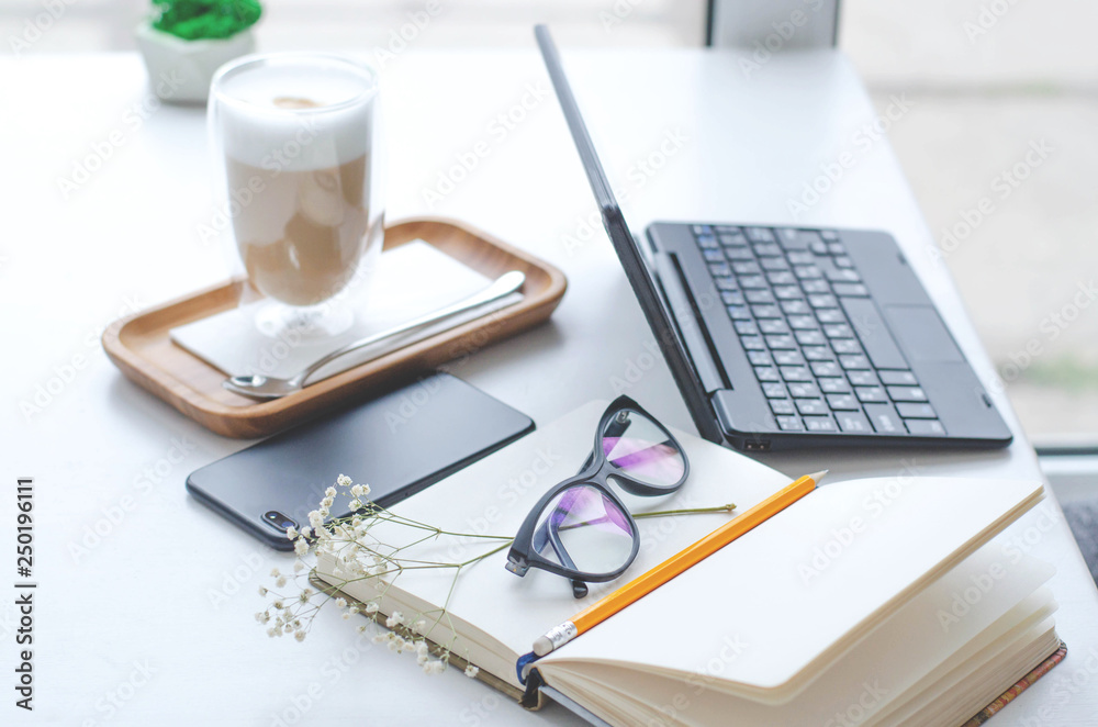 A table in a bright cafe with latte and freelancer work details. A table in a bright cafe with latte and freelancer work details.