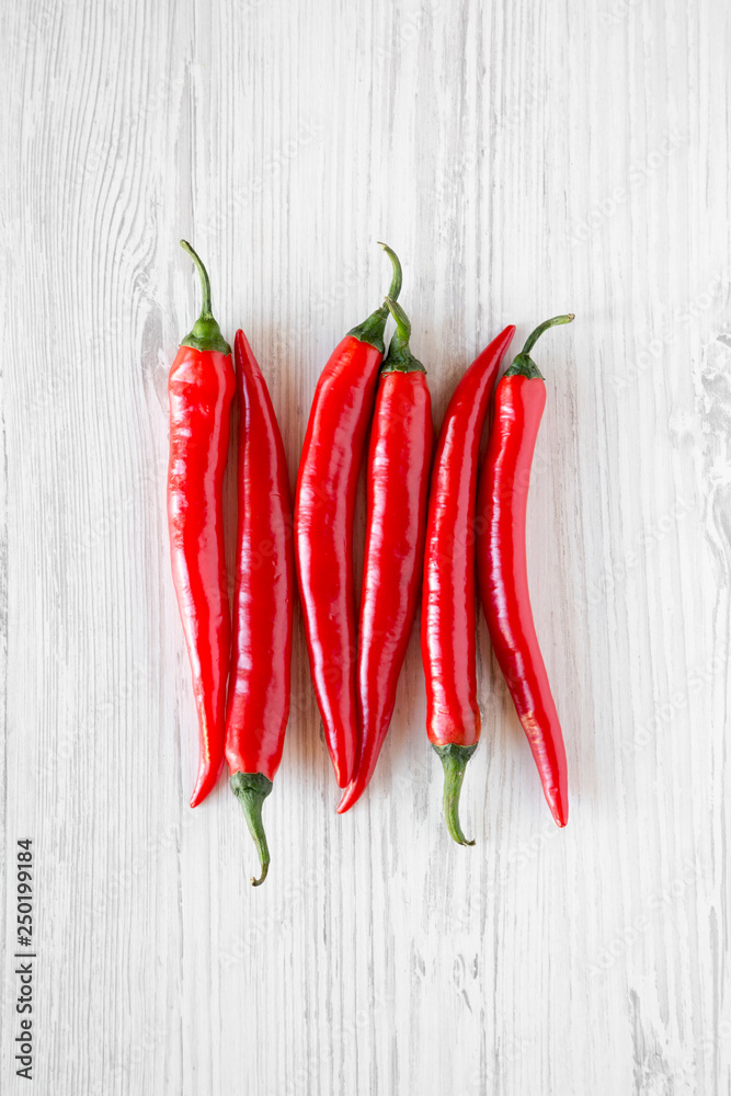 Hot red chili peppers on a white wooden background. From above, top view, flat lay. Closeup.