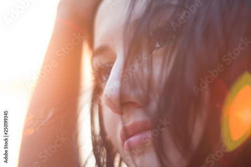 Closeup portrait of young woman in bright light of sunset. Summer