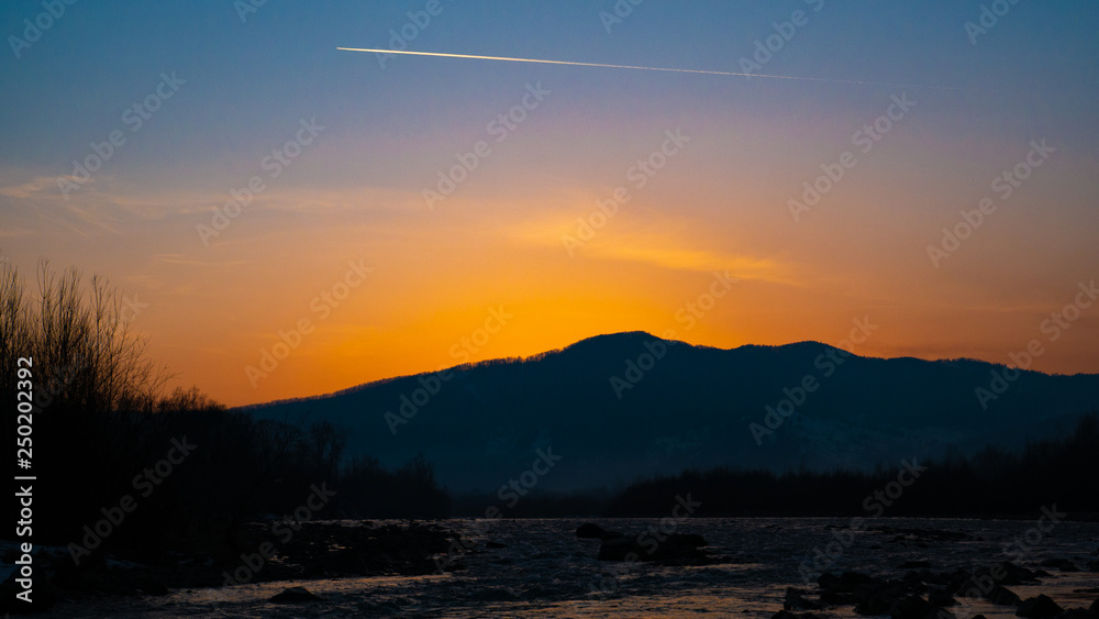 Beautiful landscape stones in mountain lake, reflection, blue sky and yellow sunlight in sunrise. Ukraine. Amazing scene