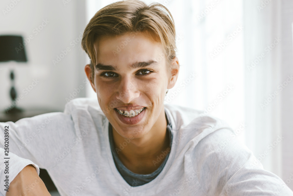 Closeup portrait of a 16 years old teenage guy wearing dental braces Closeup portrait of a 16 years old teenage guy wearing dental braces