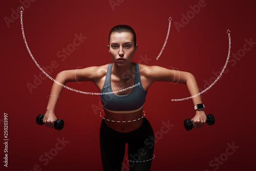 Fototapeta Naklejka Na Ścianę i Meble -  Everyday is a choice. Sportswoman holds dumbbells standing over red background. Graphic drawing.