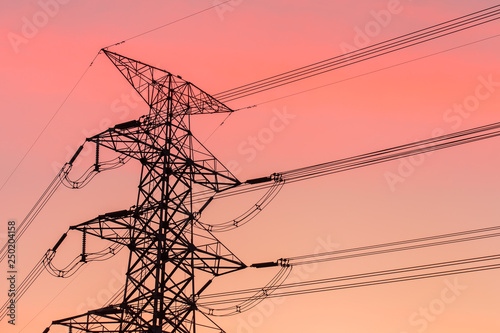 High voltage transmission lines. High voltage tower background at dusk.