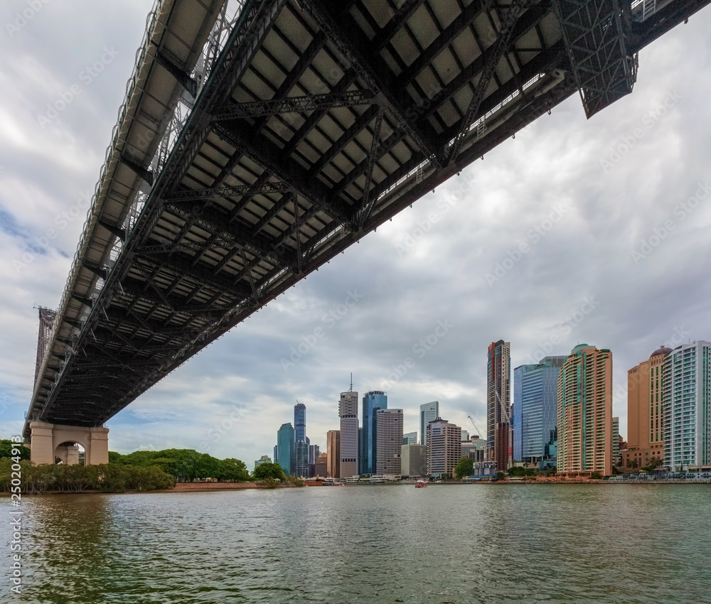 Sailing under the Story Bridge - historic cantilever bridge towards Brisbane CBD skyline Sailing under the Story Bridge - historic cantilever bridge towards Brisbane CBD skyline