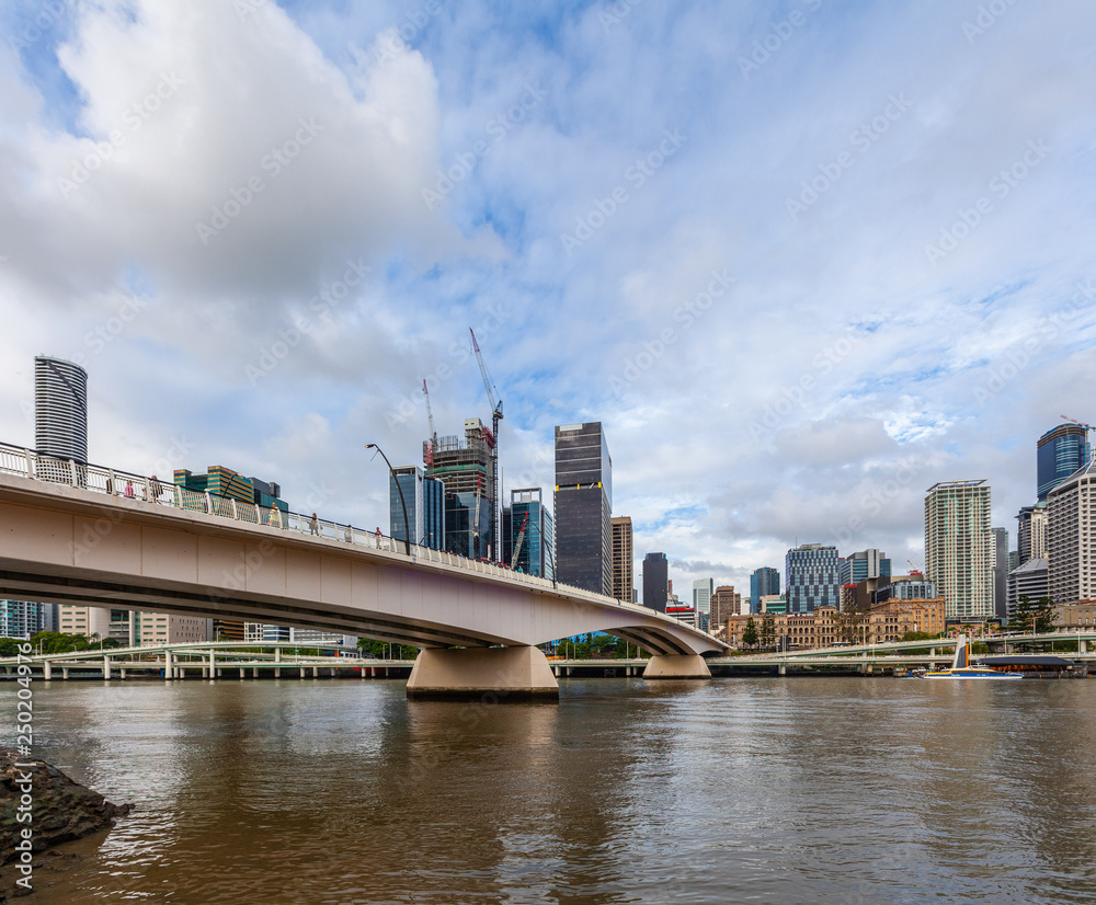 Bridge across Brisbane river and high-rise buildings on bright summer day
