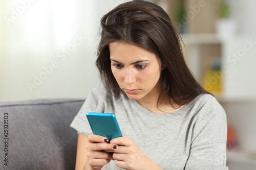 Addicted teen checking smart phone content at home