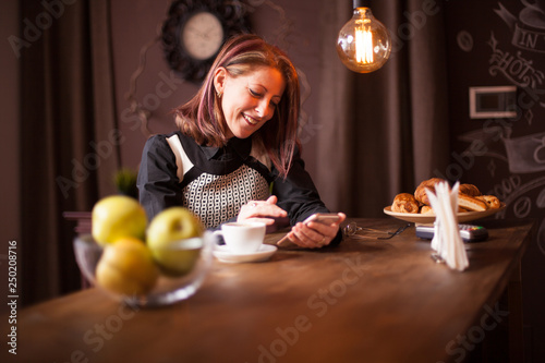 Adult business woman laughing while holding her phone