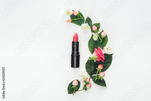 top view of composition with leaves, roses, berries, hrysanthemums and pink lipstick isolated on white photo