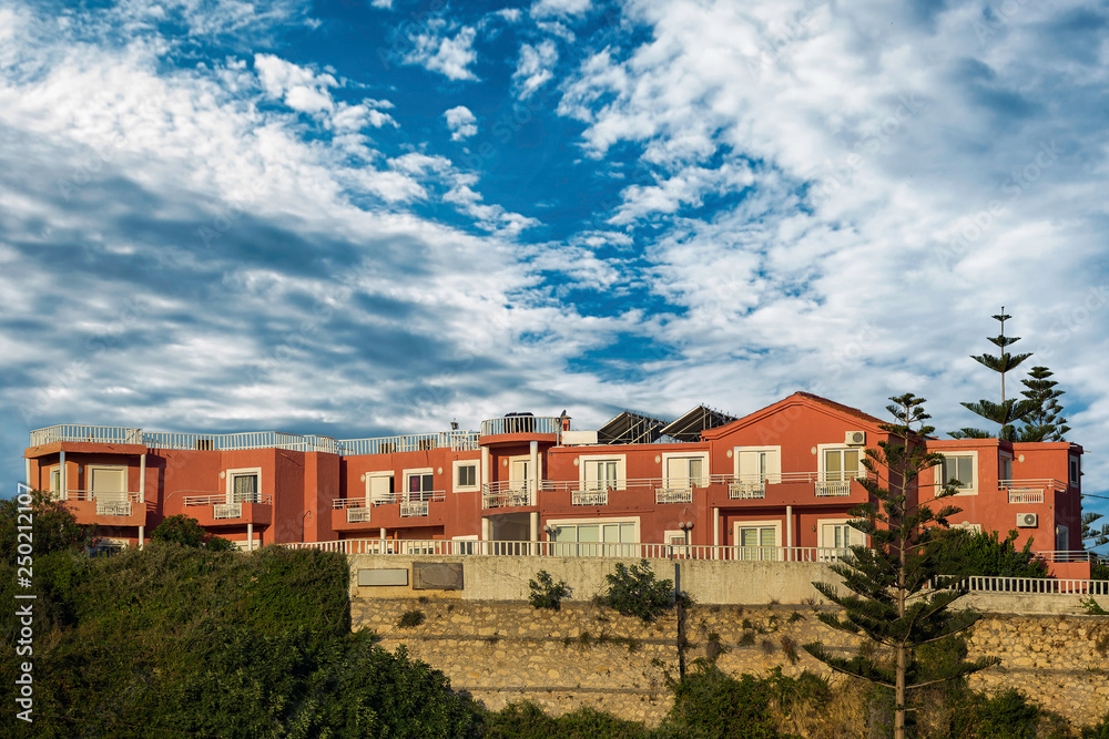 Picture of two floor apartment buildings with cloudy sky in Greece