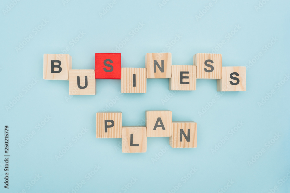 top view of business plan lettering arranged of wooden cubes on blue background top view of business plan lettering arranged of wooden cubes on blue background