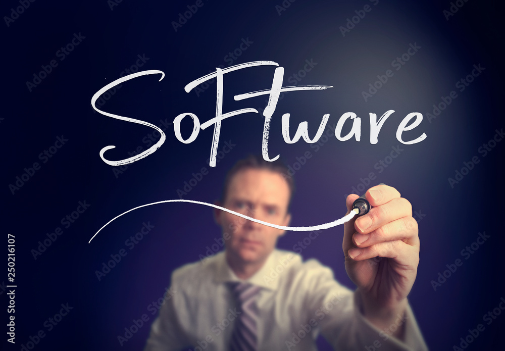 A businessman writing a Software concept with a white pen on a clear screen. A businessman writing a Software concept with a white pen on a clear screen.