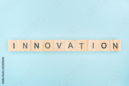top view of innovation lettering made of wooden cubes on blue background