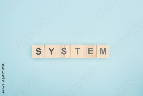 top view of system lettering made of wooden cubes on blue background