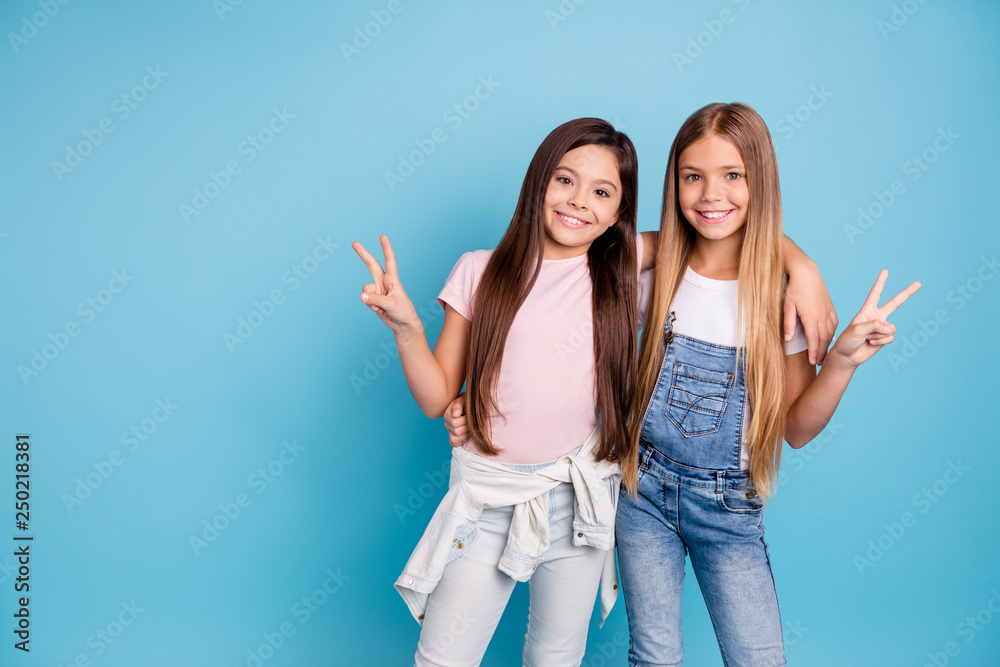 Portrait of two people nice cute lovable lovely sweet charming dreamy attractive cheerful straight-haired pre-teen girls siblings showing v-sign isolated on blue turquoise background - obrazy, fototapety, plakaty 