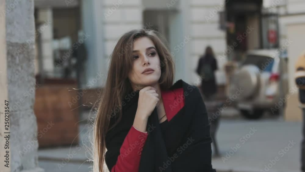 Thoughtful girl sits on street stairs and looks aside Thoughtful girl sits on street stairs and looks aside