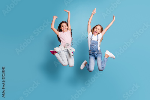 Full length body size view of two people nice-looking lovely attractive cheerful carefree straight-haired pre-teen girls having fun party overjoy great weekend isolated over blue pastel background