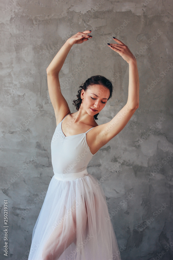 Ballet dancer ballerina in beautiful light blue dress tutu skirt posing in loft studio