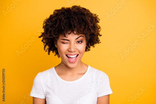 Close up photo pretty amazing she her dark skin lady cool look glad winking one eye mouth open laugh laughter wearing casual white t-shirt isolated yellow bright vibrant vivid background photo