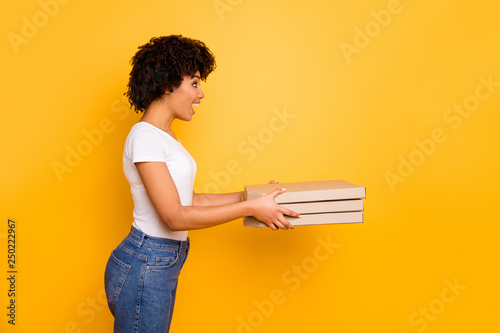 Profile side view portrait of her she nice pretty beautiful cheerful amazed wavy-haired lady jeans denim holding in hands handling three carton pizza boxes isolated over bright vivid shine background