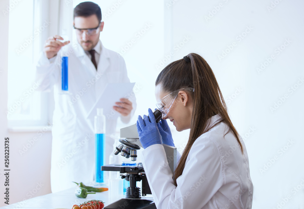 Scientists with vegetables in laboratory Scientists with vegetables in laboratory