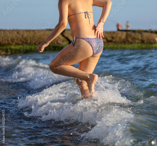 Girl in a swimsuit on the beach of the sea