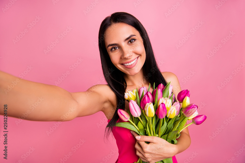 Self-portrait of her she nice cute cool adorable sweet attractive lovely fascinating charming cheerful brunette straight-haired lady holding in hands early natural flowers isolated on pink background