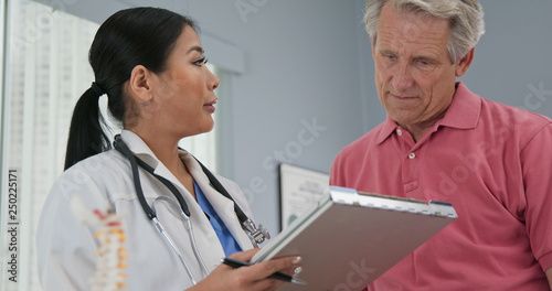 Фотография Female primary care physician taking medical history from senior Caucasian male patient
