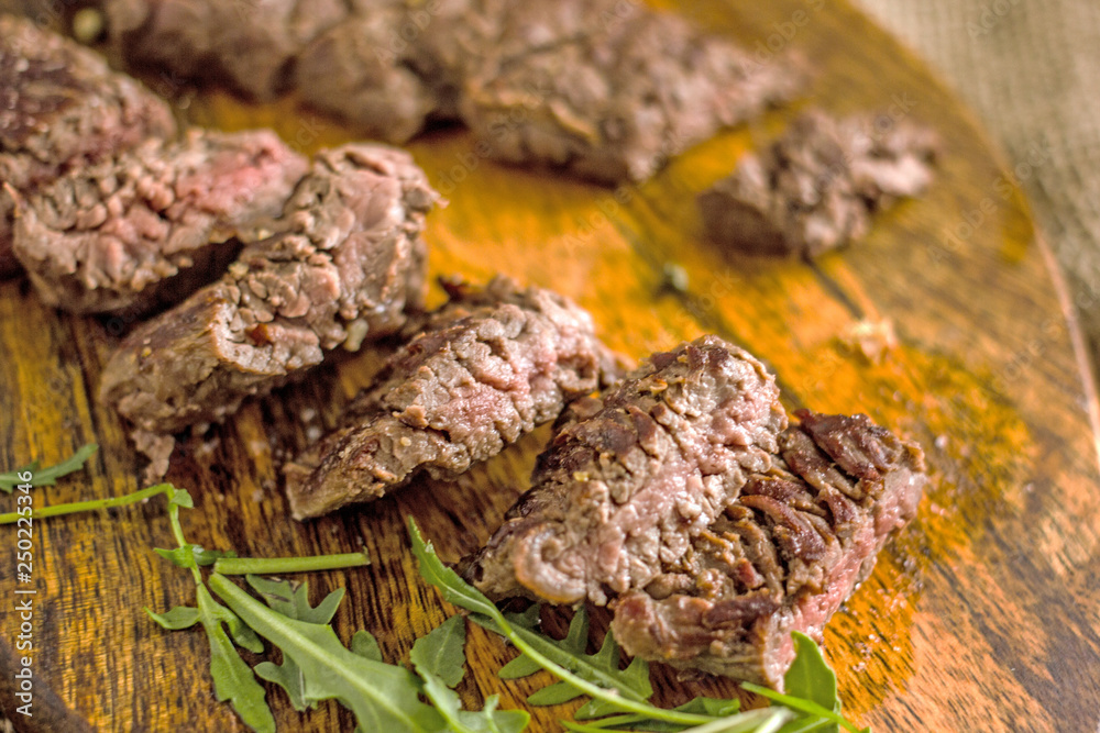 Beef Machete Steak. Grilled steak on a wooden board on a dark background. Delicious grilled meat, medium steak grilled, roast beef pieces. Machete steaks of medium roast on a wooden board Beef Machete Steak. Grilled steak on a wooden board on a dark background. Delicious grilled meat, medium steak grilled, roast beef pieces. Machete steaks of medium roast on a wooden board