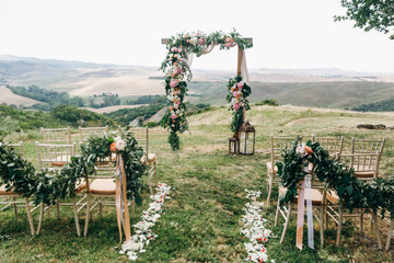 Italian wedding decoration. Green eucalyptus, oranges and pink flowers decorate wedding altar