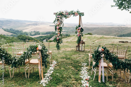 Italian wedding decoration. Green eucalyptus, oranges and pink flowers decorate wedding altar