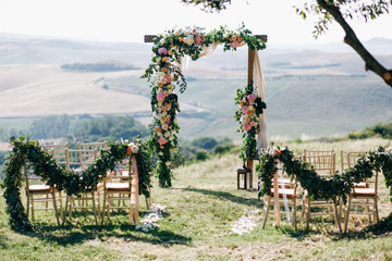 Italian wedding decoration. Green eucalyptus, oranges and pink flowers decorate wedding altar