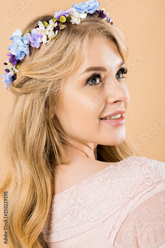 portrait of attractive woman in colorful wreath of flowers on yellow background