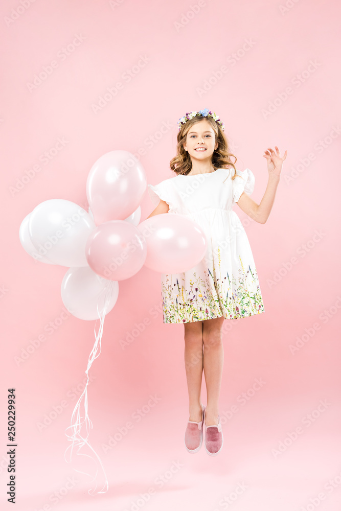 happy child in elegant white dress jumping with air balloons on pink background happy child in elegant white dress jumping with air balloons on pink background