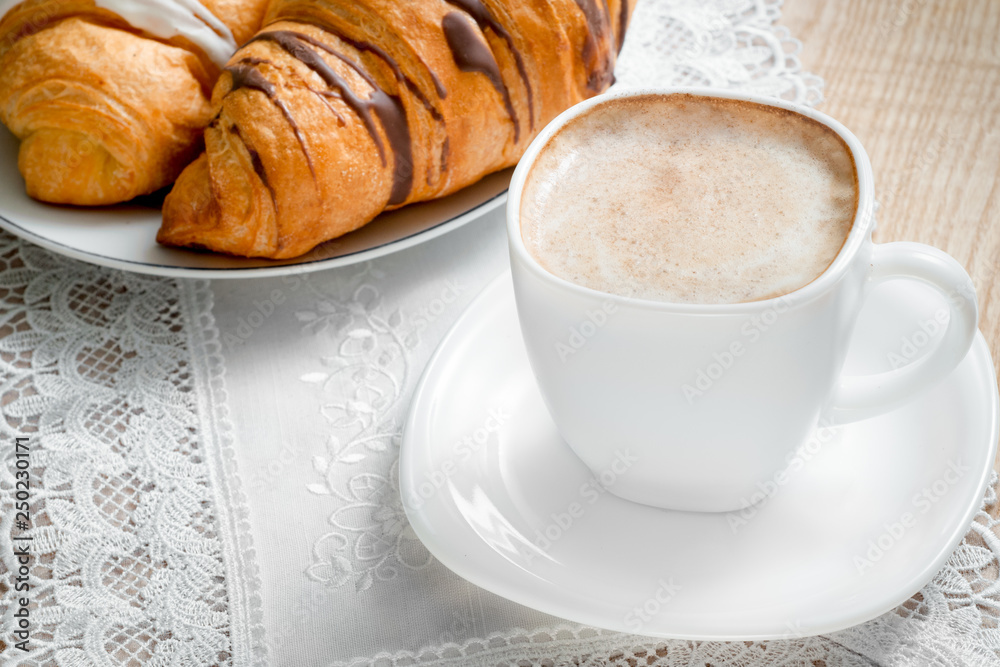 Top view on a cup of coffee with milk, croissants on a wooden table Top view on a cup of coffee with milk, croissants on a wooden table