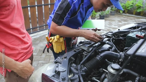 techinician help customer fixing his car in the house photo