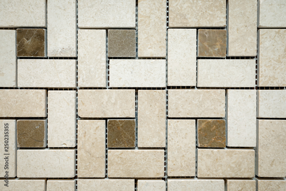 Fototapeta premium Mosaic of beige and brown marble in the form of squares and rectangles.