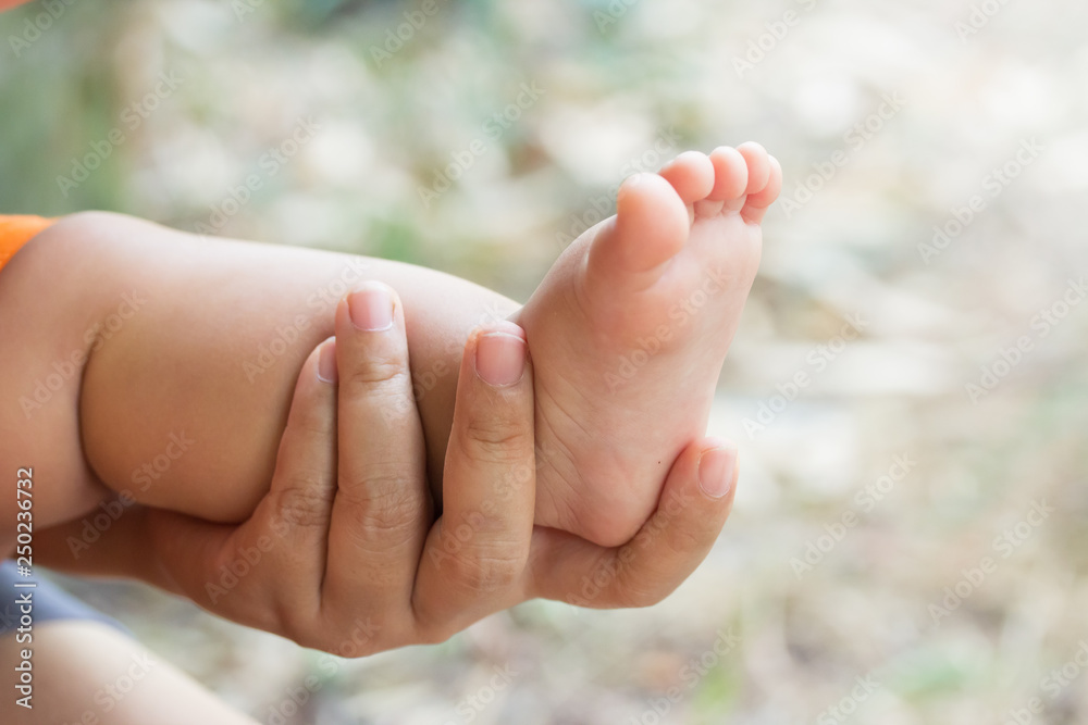 Hand catching foot cover of children Hand catching foot cover of children