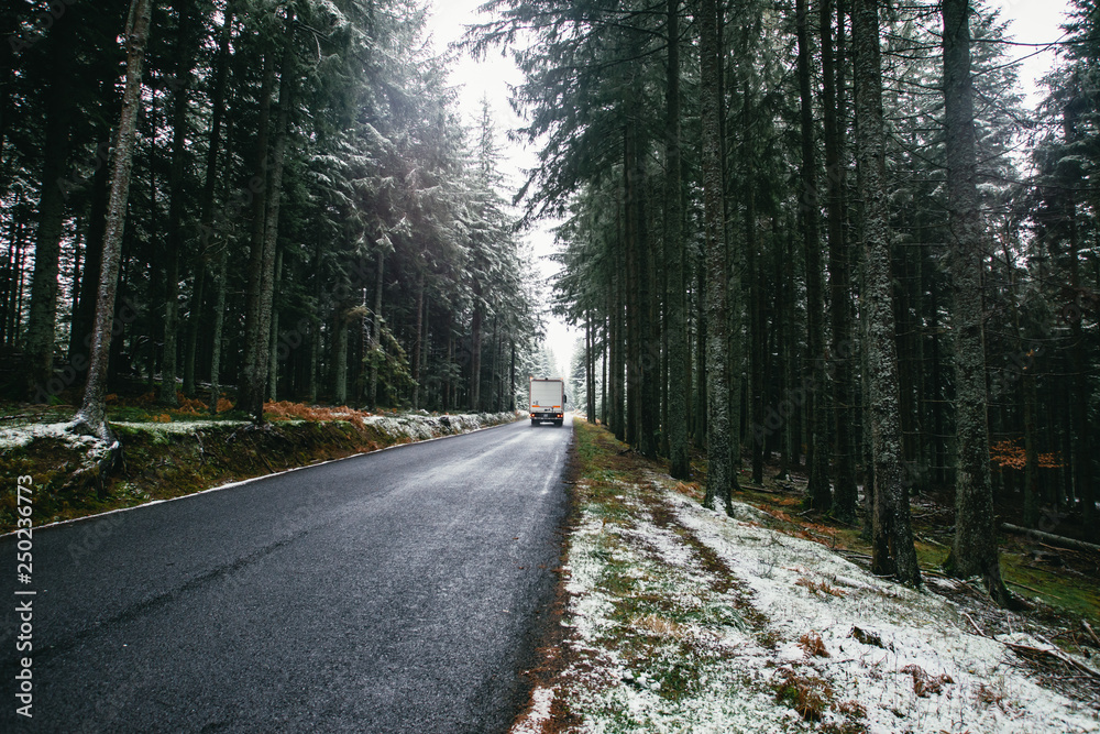 Obraz premium Truck on a road in a snow-covered forest. Winter frosty day. Trees in the hoarfrost. Ardeche, France.