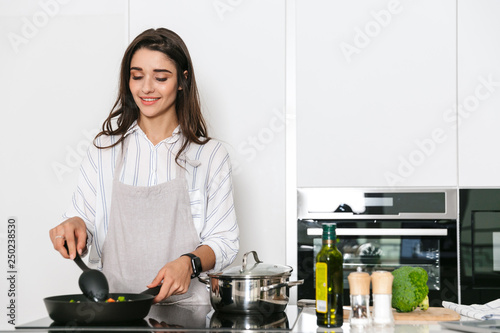 Beautiful young woman cooking healthy dinner