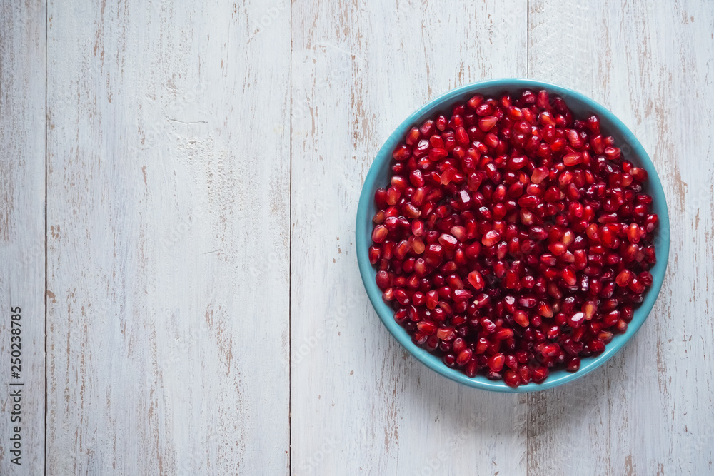 Pomegranate seeds on a white wooden table. Pomegranate seeds on a white wooden table.