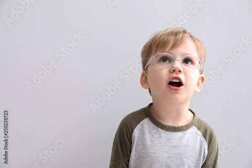 Portrait of cute little boy on light background