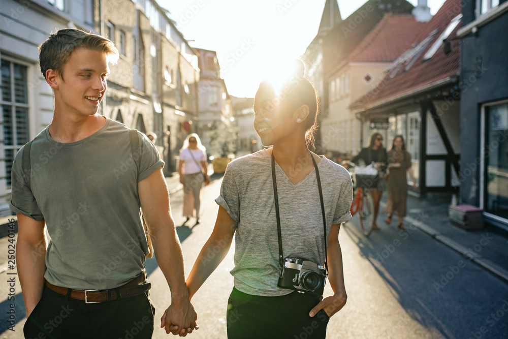 Smiling young couple exploring the city together on foot