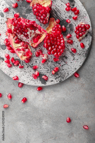 Pieces of ripe pomegranate on grey table